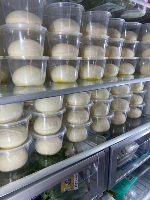 Pizza dough balls cold fermenting in containers inside a refrigerator — how long pizza dough lasts in the fridge at the Baking Steel Test Kitchen