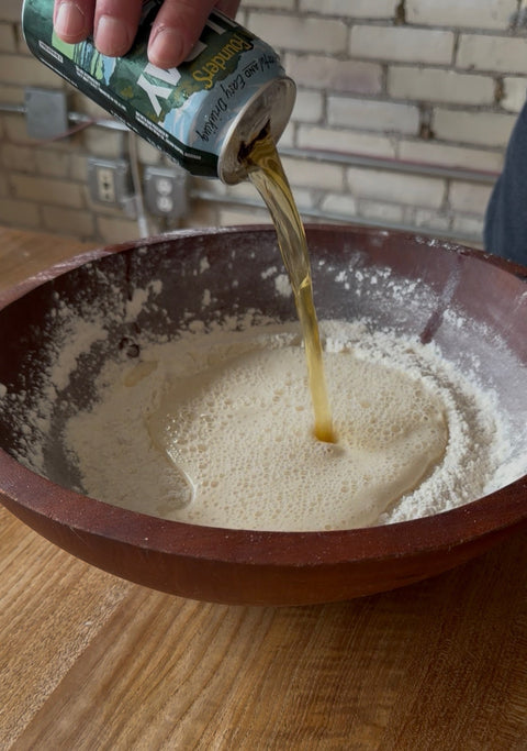 Pouring Founders Beer Into a bowl of flour for pizza dough