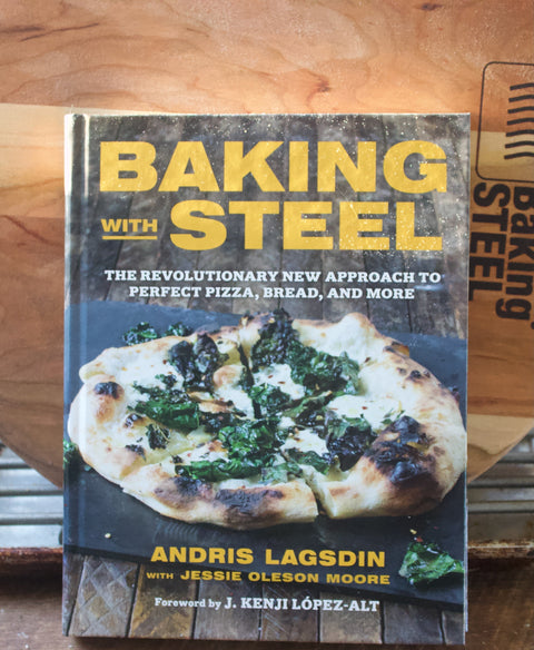 Baking with Steel cookbook by Andris Lagsdin propped against a Baking Steel pizza peel
