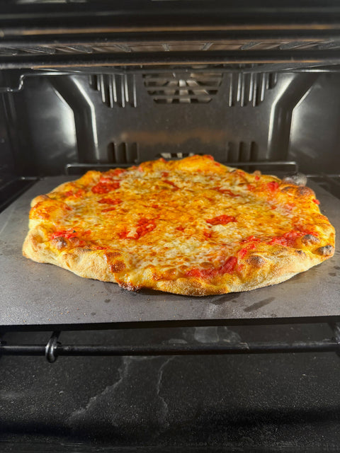 a pizza reheating on a Baking Steel inside a home oven