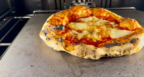 Neapolitan-style pizza with leopard-spotted crust and fresh mozzarella baking on a Baking Steel inside a home oven