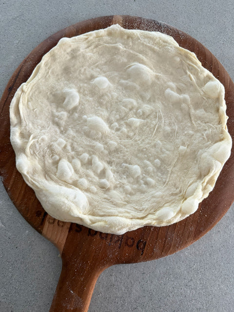 72 hour pizza dough stretched ona pizza peel