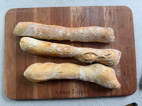 Three freshly baked stirato Italian baguettes on a Baking Steel bread board