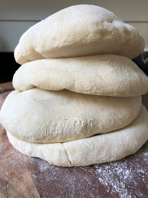 3 hour pita bread after the bake on a counter stacked 