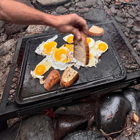 Eggs and toast on a Baking Steel Griddle over a camp fire