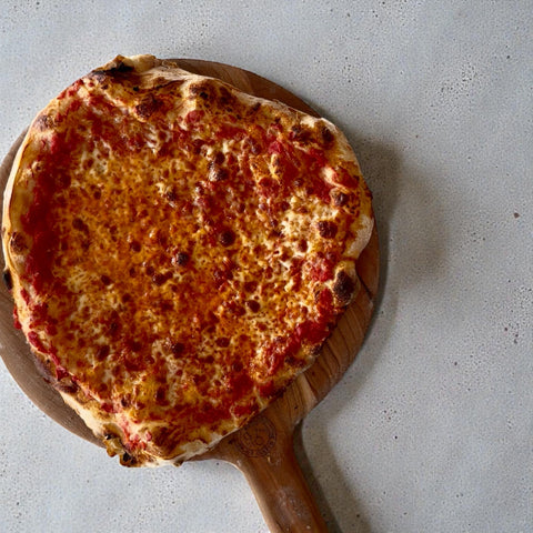 Same-day pizza dough recipe - golden cheese pizza on wooden peel made with 8-hour dough
