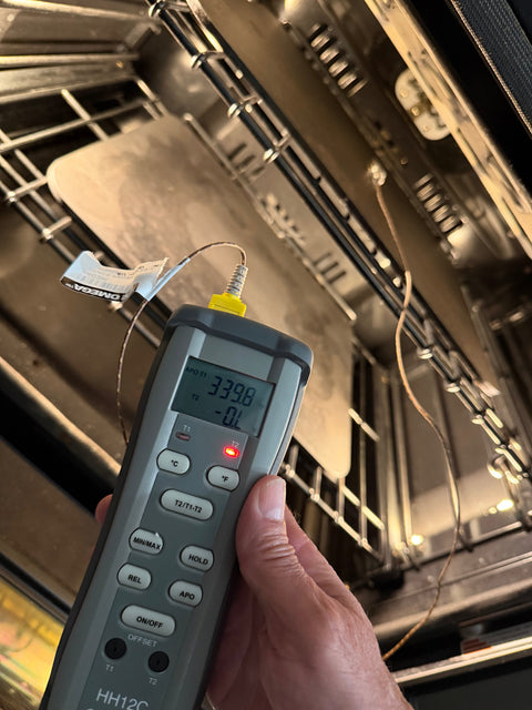 Omega HH12C thermocouple meter reading 339.8°F, with the probe wire running to a Baking Steel on the oven rack