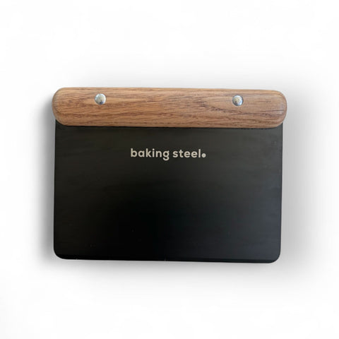 Baking Steel artisan dough cutter with walnut wood handle and black stainless steel blade on white background