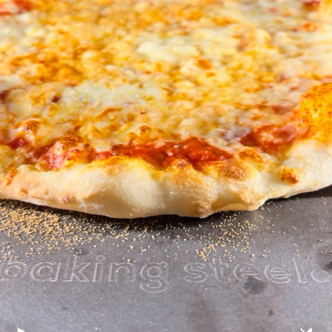 Cheesy pizza on a baking steel with visible branding